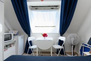 a bedroom with a window with two chairs and a table at Couette et café in Arradon +12 photos
