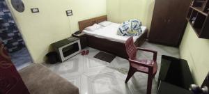 a small bedroom with a bed and a tv at Hotal Relax in Saharsa