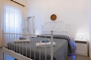 a bedroom with a white bed with towels on it at Trullo Petronella in Cisternino +30 photos