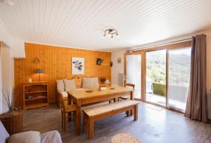 a living room with a wooden table and a couch at L'Edelweiss - Bouvier in Aillon-le-Jeune