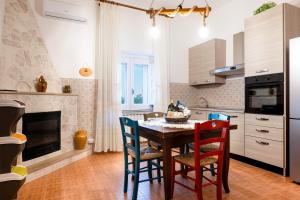 a kitchen with a table with chairs and a fireplace at Trullo Petronella in Cisternino