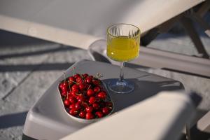 a bowl of cherries and a glass of orange juice at Villa Stone in Smoković