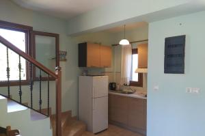a kitchen with a white refrigerator and a staircase at Steni Vala Apartments in Steni Vala Alonissos +45 photos