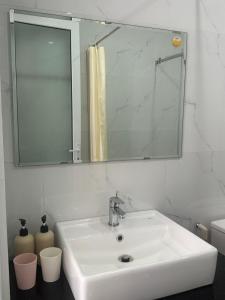 a bathroom with a white sink and a mirror at Viha Homestay in Thôn Trường Giang