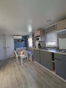 a kitchen with a table and chairs in a room at Camping Le Chassezac in Sampzon +21 photos