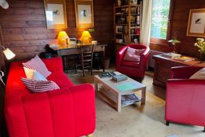 a living room with red chairs and a table at Little Paradise hidden from view in Liézey