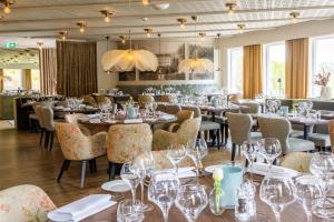 a restaurant with tables and chairs and wine glasses at Aspenäs Herrgård in Lerum