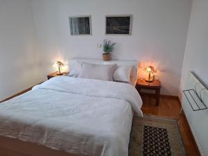 a bedroom with a white bed with two lamps at Dinaki apartment in Florina