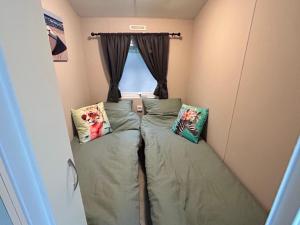 a room with two beds and a window at Leuke 6 persoons stacaravan op top locatie! in Hoenderloo +15 photos
