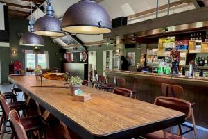 a large wooden table in a restaurant with a bar at Leuke 6 persoons stacaravan op top locatie! in Hoenderloo