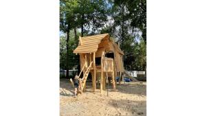 a little boy standing in front of a play house at Leuke 6 persoons stacaravan op top locatie! in Hoenderloo