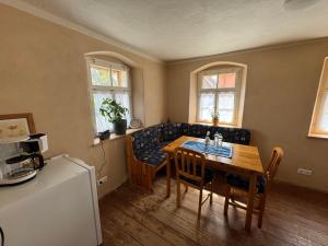 a dining room with a table and chairs and a kitchen at Glücksschmiede Hennersdorf in Dippoldiswalde