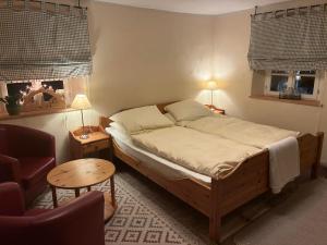 a bedroom with a bed and a chair and a table at Glücksschmiede Hennersdorf in Dippoldiswalde