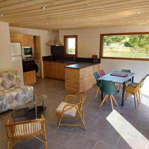 a kitchen and living room with a table and chairs at Chalet Les Noisetiers in Rochesson