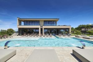 a house with a swimming pool in front of a building at San Servolo Wellness Rooms - Adults Only in Buje