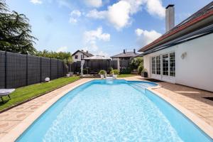 a swimming pool in the backyard of a house at Villa Béatrice - Piscine in Hochfelden