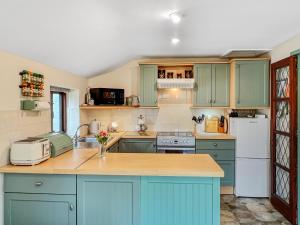 a kitchen with blue cabinets and a counter top at The Coach House Dulverton in Dulverton