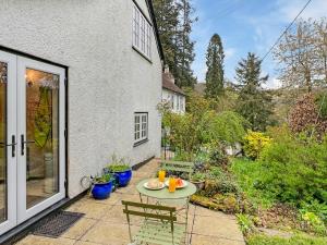 a patio with a table and chairs in a yard at The Coach House Dulverton in Dulverton