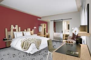 a bedroom with a white bed and a red wall at Domaine de l'éclaircie in Saint-Quirin