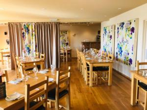 a dining room with wooden tables and chairs at The Poltimore Inn in North Molton