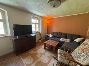 a living room with a couch and a flat screen tv at Glücksschmiede Hennersdorf in Dippoldiswalde