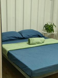 a bed with blue sheets and a green pillow on it at Villa Concepcion Staycation by ngb in Real