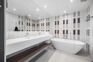 a white bathroom with two sinks and a tub at Comfort Hotel Grimstad in Grimstad +36 photos