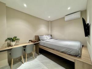 a bedroom with a bed and a desk with chairs at WH302 Residence by WH in Phnom Penh