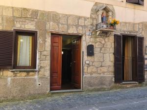 a stone building with two doors and a balcony at The Stone House Historic Center in Grotte di Castro
