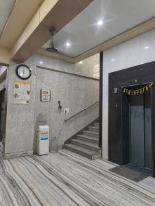 a lobby with stairs and a clock on the wall at Gopal Dham in Govardhan +21 photos