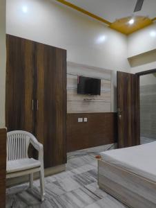 a bedroom with a bed and a tv on a wall at Gopal Dham in Govardhan