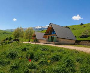 a house on a hill with a field of grass at Shahdag A-Frame in Qusar