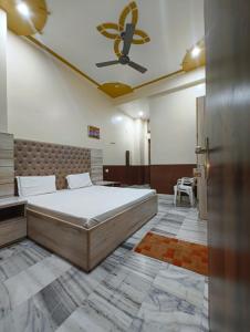 a bedroom with a bed and a ceiling fan at Gopal Dham in Govardhan