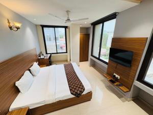 a bedroom with a large bed and a flat screen tv at La Casa Residency in Lucknow
