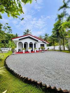 a house with a gravel driveway in front of it at Beach Star Villa Beruwala in Beruwala