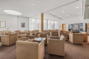 a waiting room with brown chairs and tables at City Best Autobahnhotel Stolper Heide in Berlin