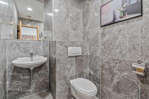 a bathroom with a toilet and a sink at City Best Autobahnhotel Stolper Heide in Berlin +5 photos