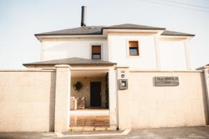 a white brick house with a door open at Villa Montalvo Beach-Piscina climatizada in Montalvo