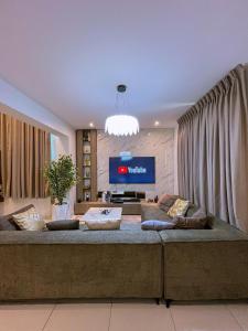a living room with a large couch and a television at Abbey's Home in Ogoyo