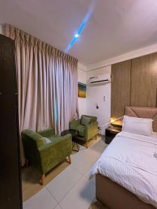 a bedroom with a bed and a couch and a chair at Abbey's Home in Ogoyo +1 photo