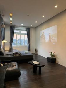 a living room with a bed and a couch at MiMo Homestay Đà Lạt in Xuan An