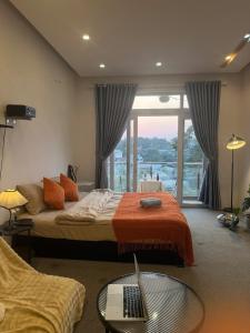 a bedroom with a bed with a laptop on it at MiMo Homestay Đà Lạt in Xuan An