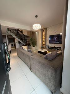 a living room with a large couch and a tv at Abbey's Home in Ogoyo