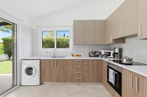 a kitchen with a washer and dryer at Bungalow Casa Bella by Ezoria Villas in Coral Bay