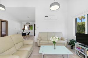 a living room with two couches and a table at Bungalow Casa Bella by Ezoria Villas in Coral Bay