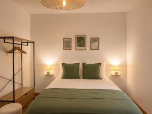 a bedroom with a bed with two green pillows at Au coeur de Vernon - Appartement 4 pers - à 10min Giverny in Vernon