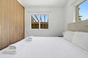 a white bedroom with a bed with towels on it at Bungalow Casa Bella by Ezoria Villas in Coral Bay +15 photos