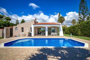a villa with a swimming pool in front of a house at Bungalow Casa Bella by Ezoria Villas in Coral Bay