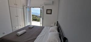 a bedroom with a bed with two towels on it at Aquarius Kefalonia in Pesádha