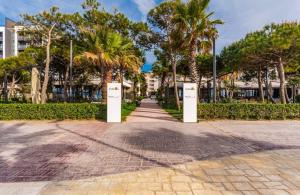 a walkway with palm trees in a park at Lika's Residence in Golem